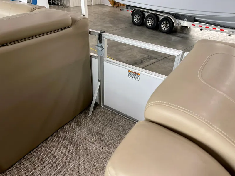 Slide: The Image of Interior of 2023 Starcraft LX 22 R boat with beige seating and safety gate. - 10