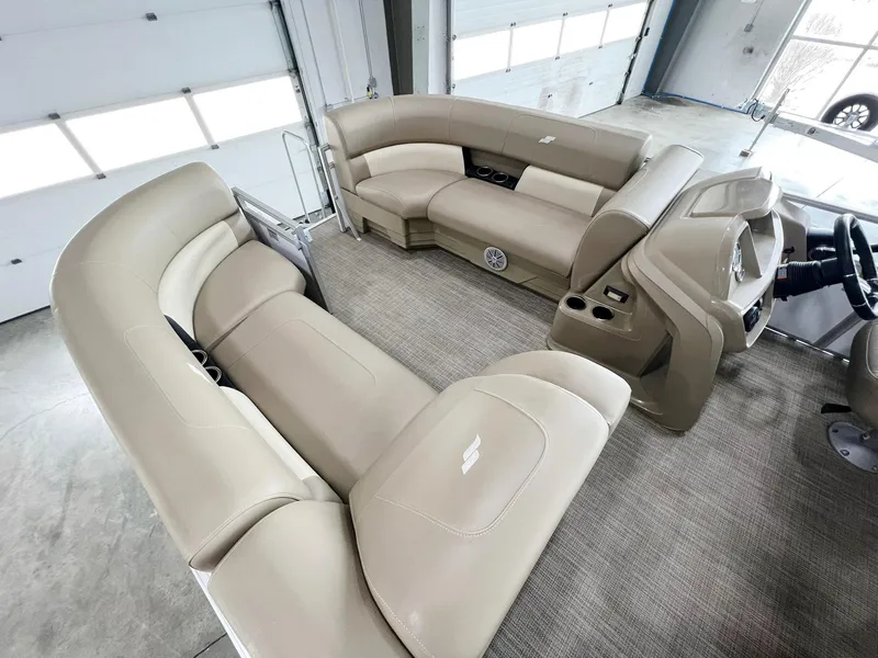 Slide: The Image of 2023 Starcraft LX 22 R pontoon boat interior with beige seating and modern dashboard. - 14
