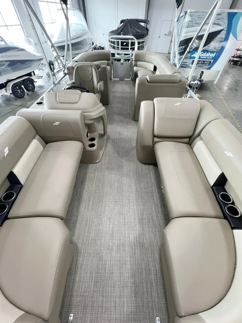 Slide: The Image of 2023 Starcraft LX 22 R pontoon boat interior with beige seating and modern design. - 15