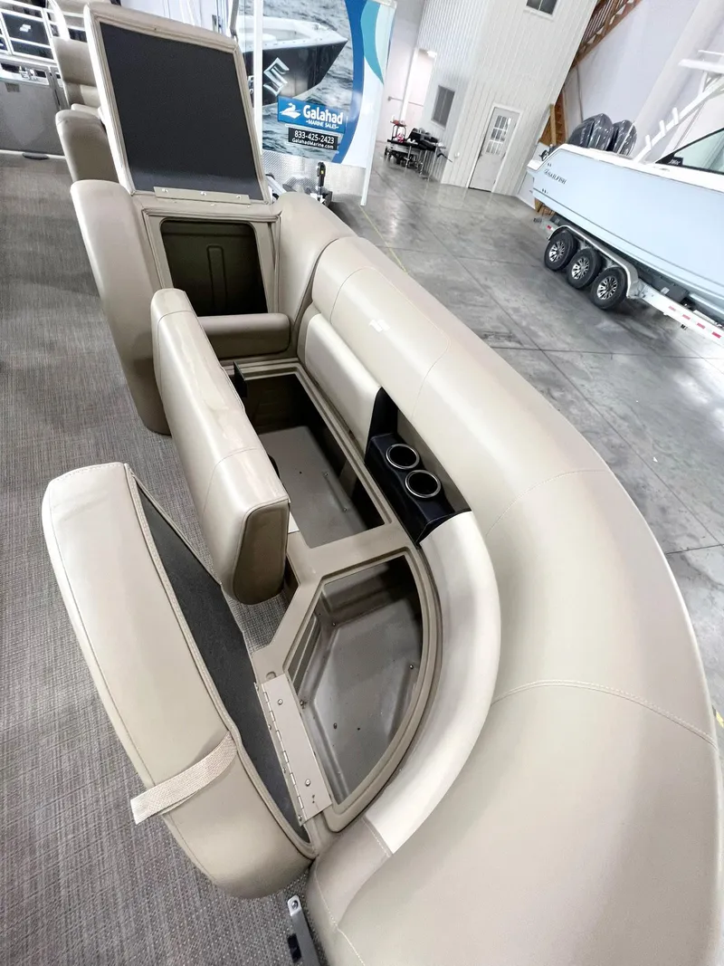 Slide: The Image of 2023 Starcraft LX 22 R boat interior with open storage compartments and cup holders. - 17