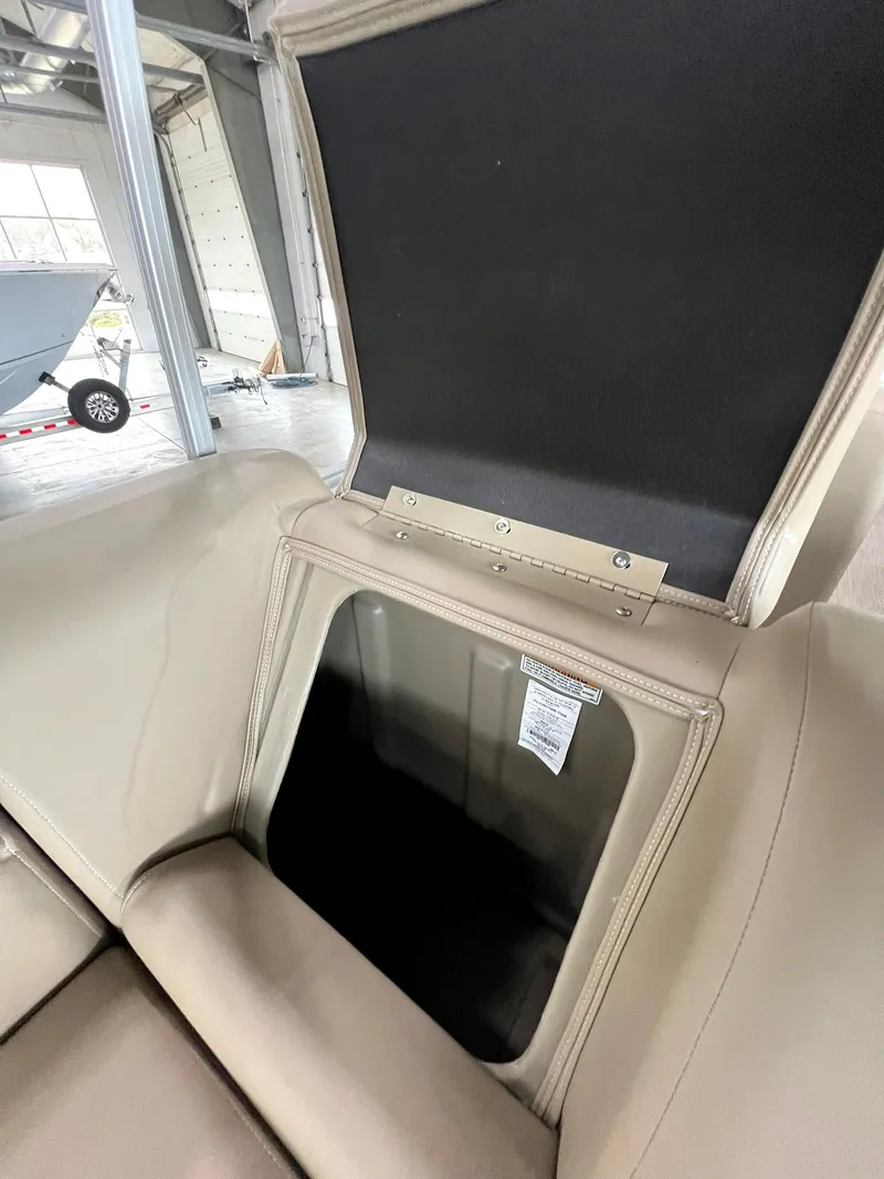 Slide: The Image of 2023 Starcraft LX 22 R boat storage compartment with open lid in a showroom. - 20