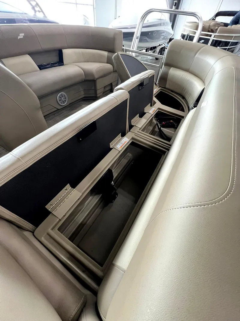 Slide: The Image of 2023 Starcraft LX 22 R boat interior with open storage compartments and beige seating. - 22
