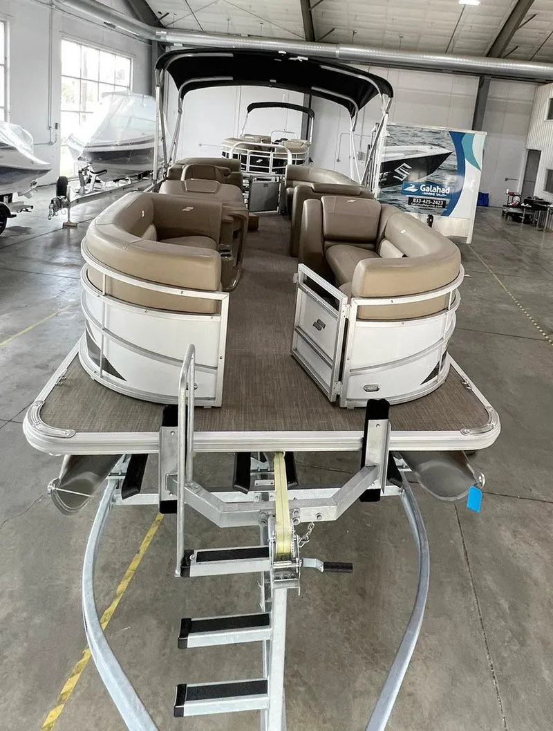Slide: The Image of 2023 Starcraft LX 22 R pontoon boat in showroom, featuring spacious seating and modern design. - 29