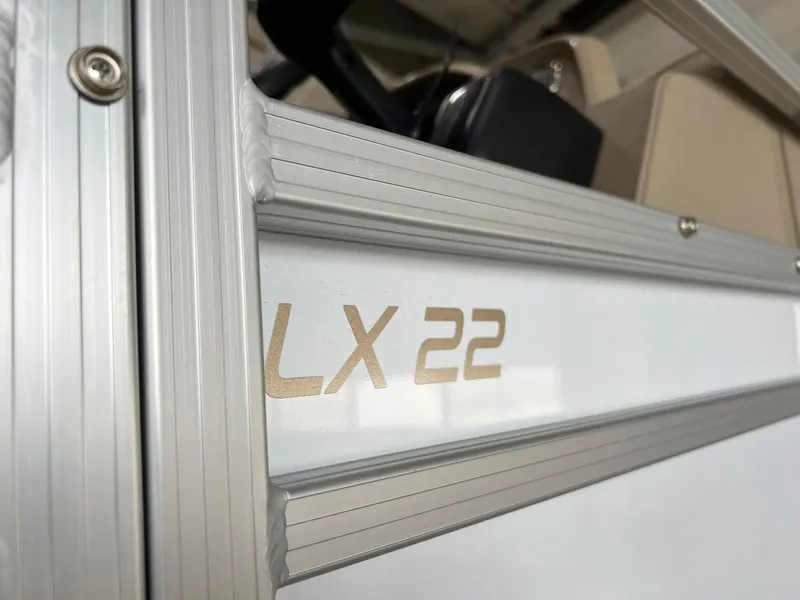 Slide: The Image of 2023 Starcraft LX 22 R boat detail with metallic trim and model name. - 35