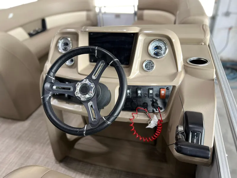 Slide: The Image of 2023 Starcraft LX 22 R boat dashboard with steering wheel and control panel. - 4