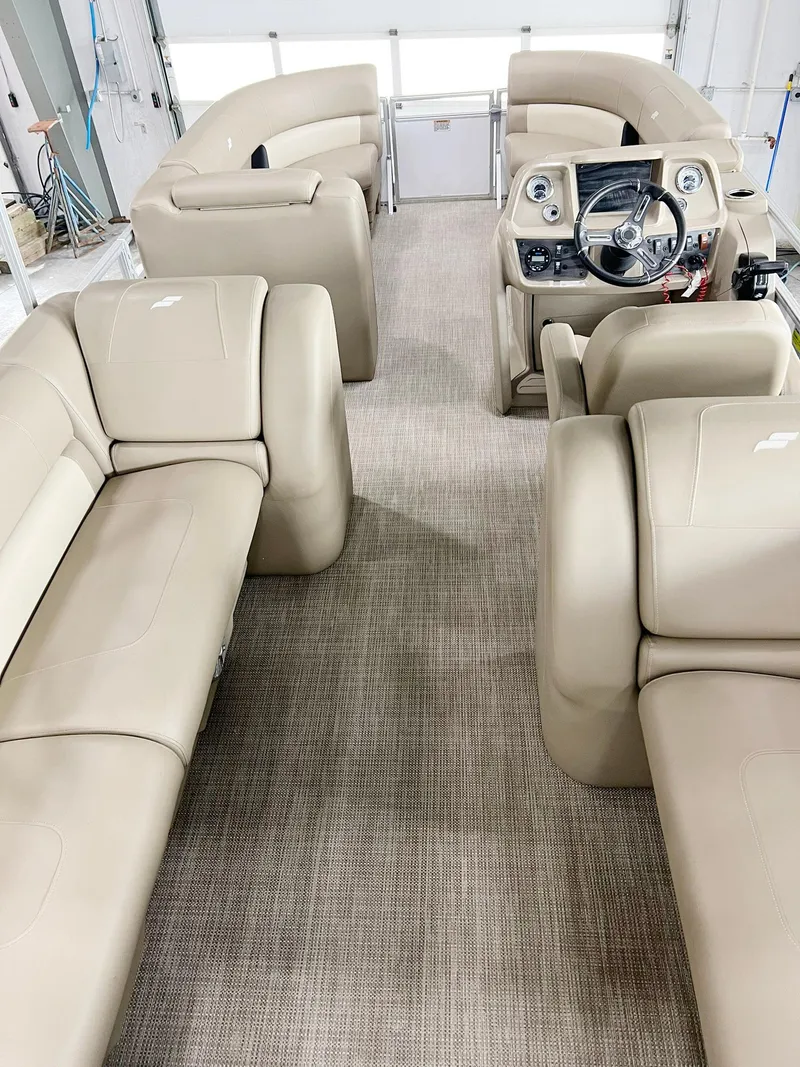 Slide: The Image of Interior of 2023 Starcraft LX 22 R boat with beige seating and steering console. - 8