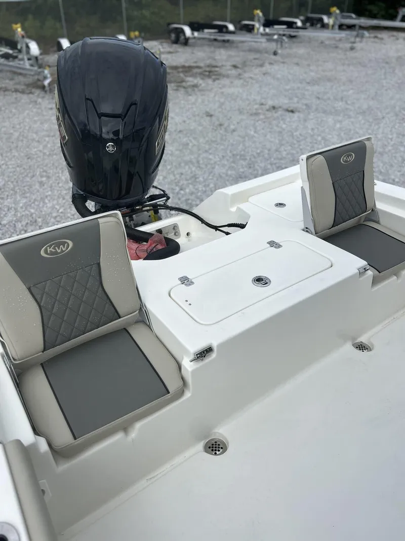 Slide: The Image of 2025 Key West 230BR boat interior with cushioned seating and outboard motor. - 10
