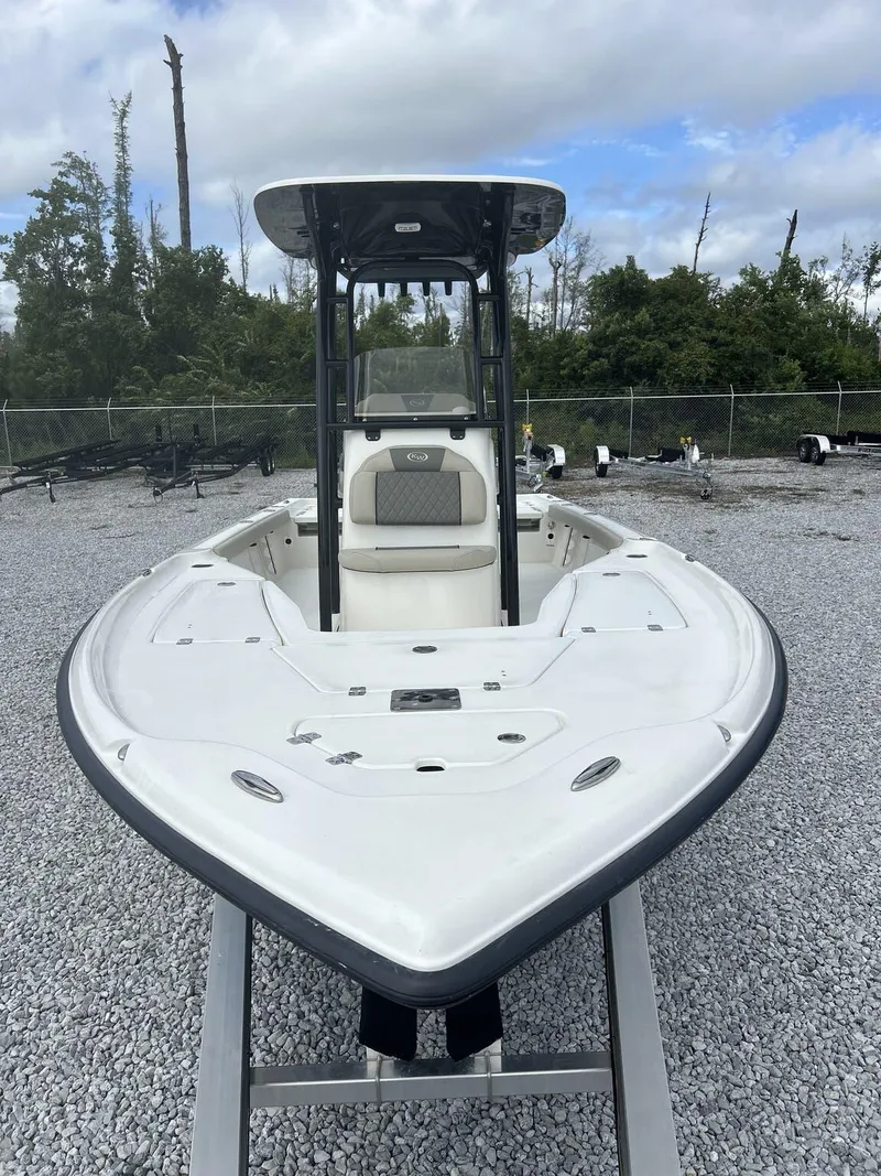 Slide: The Image of 2025 Key West 230BR boat on gravel lot, overcast sky, forest background. - 12