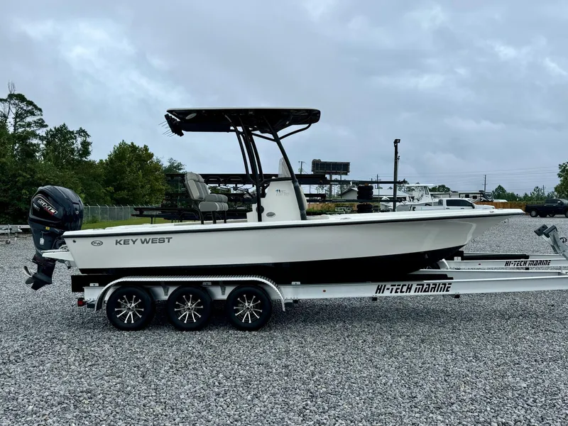 Slide: The Image of 2025 Key West 230BR boat on trailer, parked on gravel lot. - 3