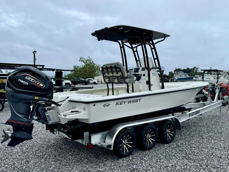 Slide: The Image of 2025 Key West 230BR boat on trailer with Yamaha engine, parked on gravel. - 4