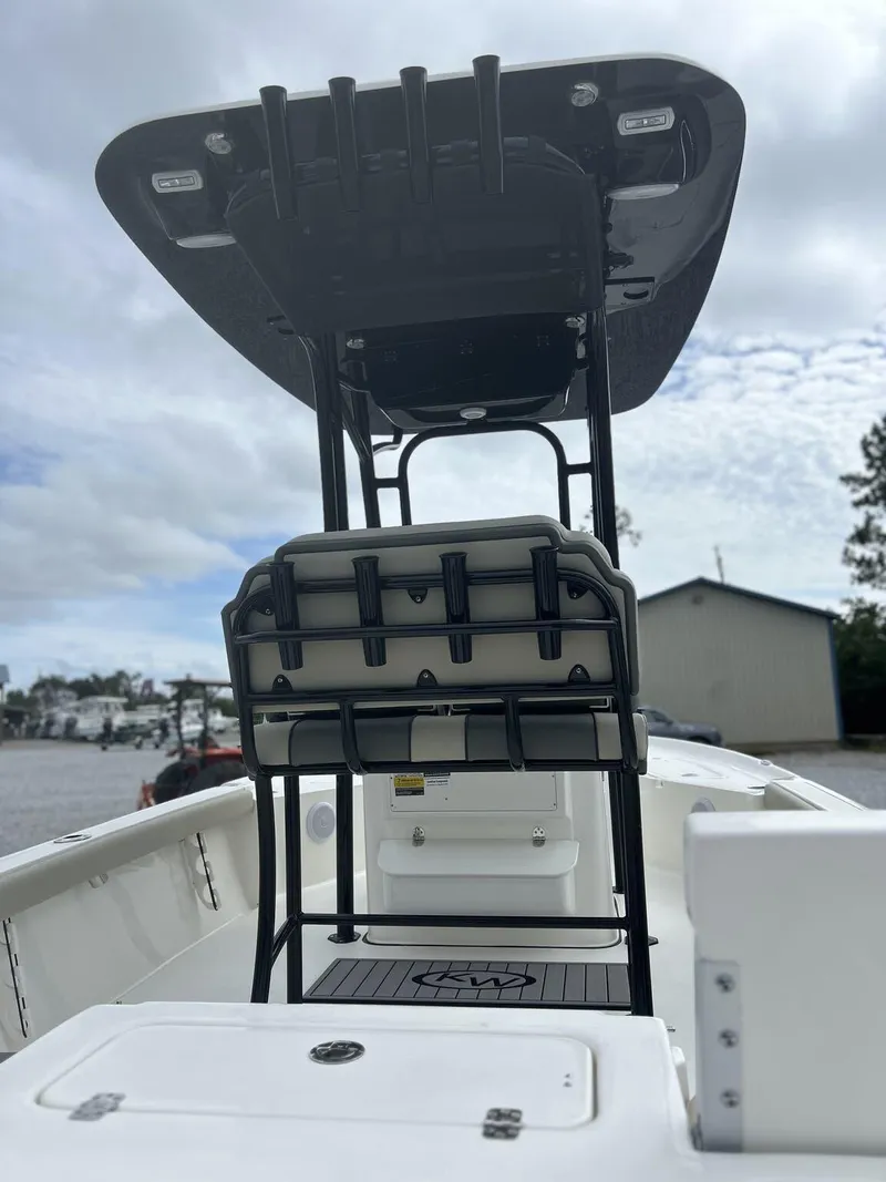 Slide: The Image of 2025 Key West 230BR boat interior with seating and storage, docked under cloudy skies. - 7