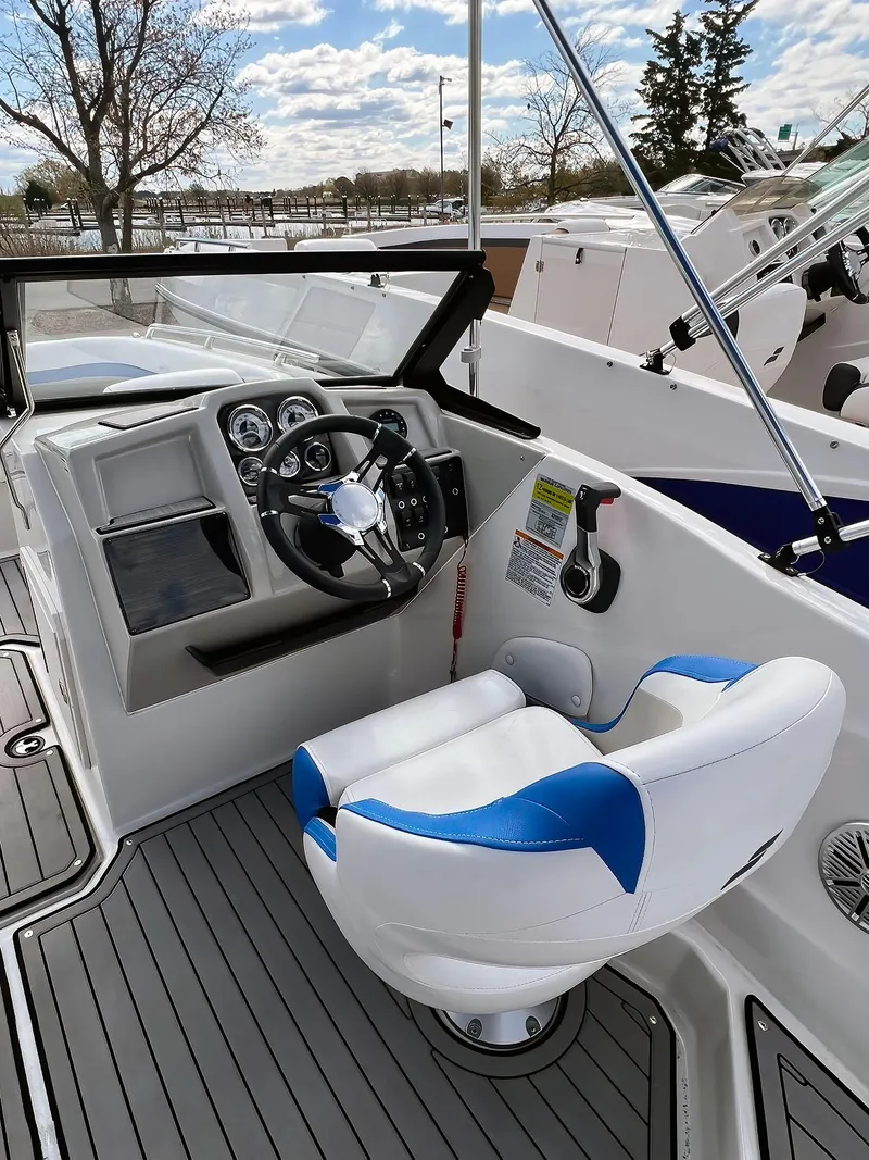 Slide: The Image of 2023 Starcraft SVX 190 OB boat cockpit with steering wheel and captain's chair. - 14