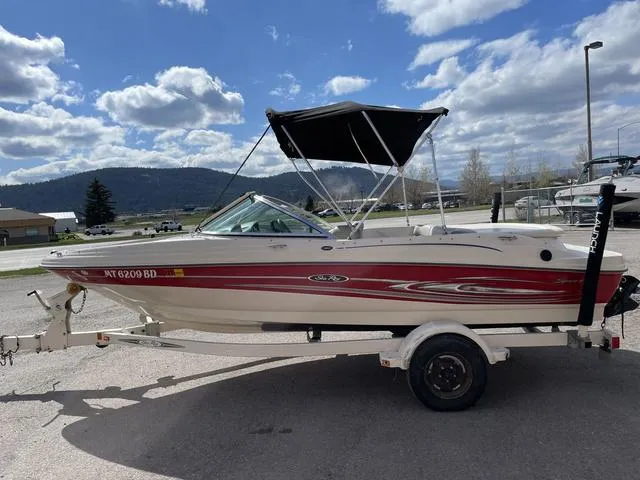 Slide: The Image of 2005 Sea Ray 180 Sport boat on trailer, parked outdoors under cloudy sky. - 5