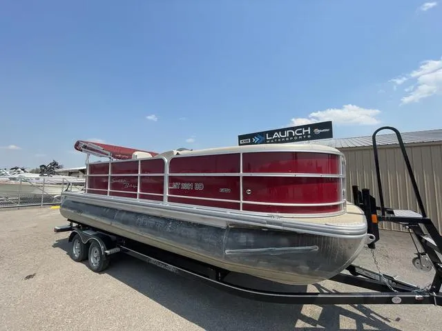 Slide: The Image of 2019 South Bay 222CR 2.75 pontoon boat on trailer, red and silver design. - 3