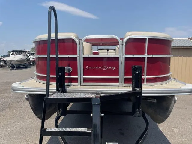 Slide: The Image of 2019 South Bay 222CR 2.75 pontoon boat with red exterior, docked on trailer. - 4