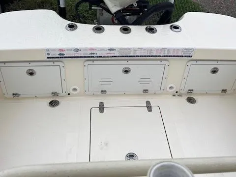 Slide: The Image of 2021 BlackJack 256 Coastal Bay boat deck with storage compartments and rod holders. - 12