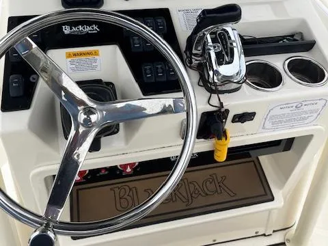 Slide: The Image of 2021 BlackJack 256 Coastal Bay boat dashboard with steering wheel and controls. - 7