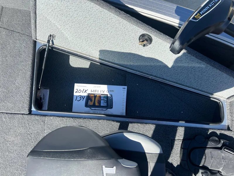 Slide: The Image of 2025 Lund 2075 IMPACT XS boat interior with storage compartment and control panel. - 10