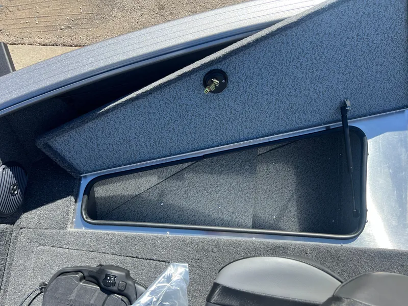Slide: The Image of 2025 Lund 2075 IMPACT XS boat storage compartment with open lid, showcasing interior space. - 11