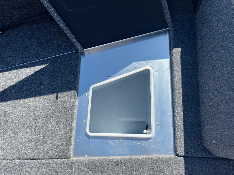 Slide: The Image of 2025 Lund 2075 IMPACT XS boat interior storage compartment with gray carpet. - 12