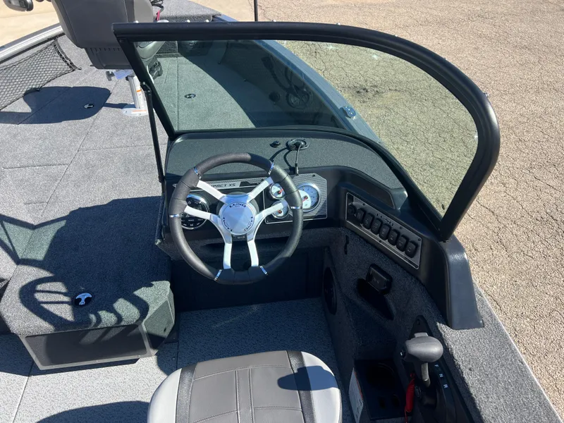 Slide: The Image of 2025 Lund 2075 IMPACT XS boat interior with steering wheel and dashboard controls. - 17