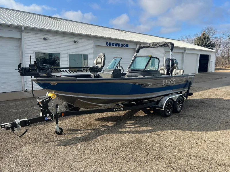 Slide: The Image of 2025 Lund 2075 IMPACT XS boat on trailer outside showroom. - 2
