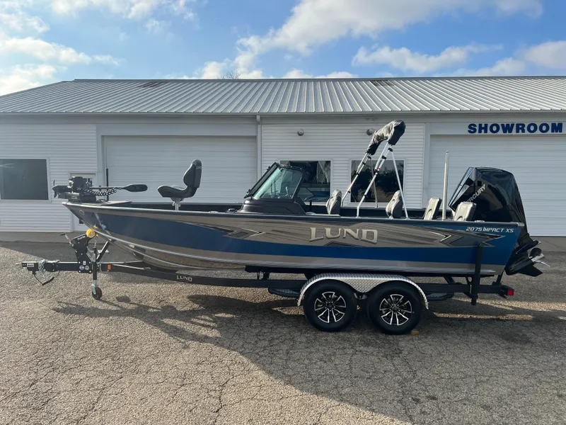 Slide: The Image of 2025 Lund 2075 IMPACT XS boat parked outside showroom on trailer. - 4