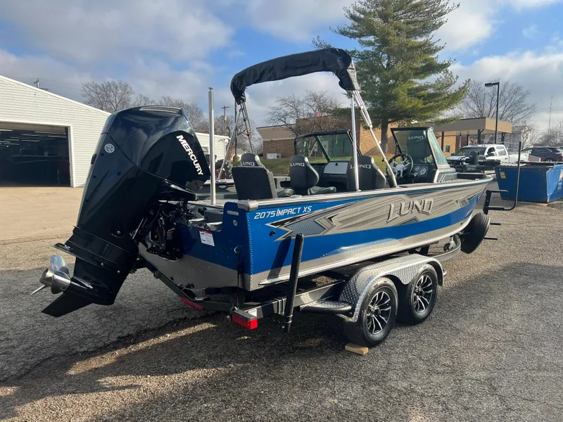 Slide: The Image of 2025 Lund 2075 IMPACT XS boat on trailer, parked outdoors. - 5