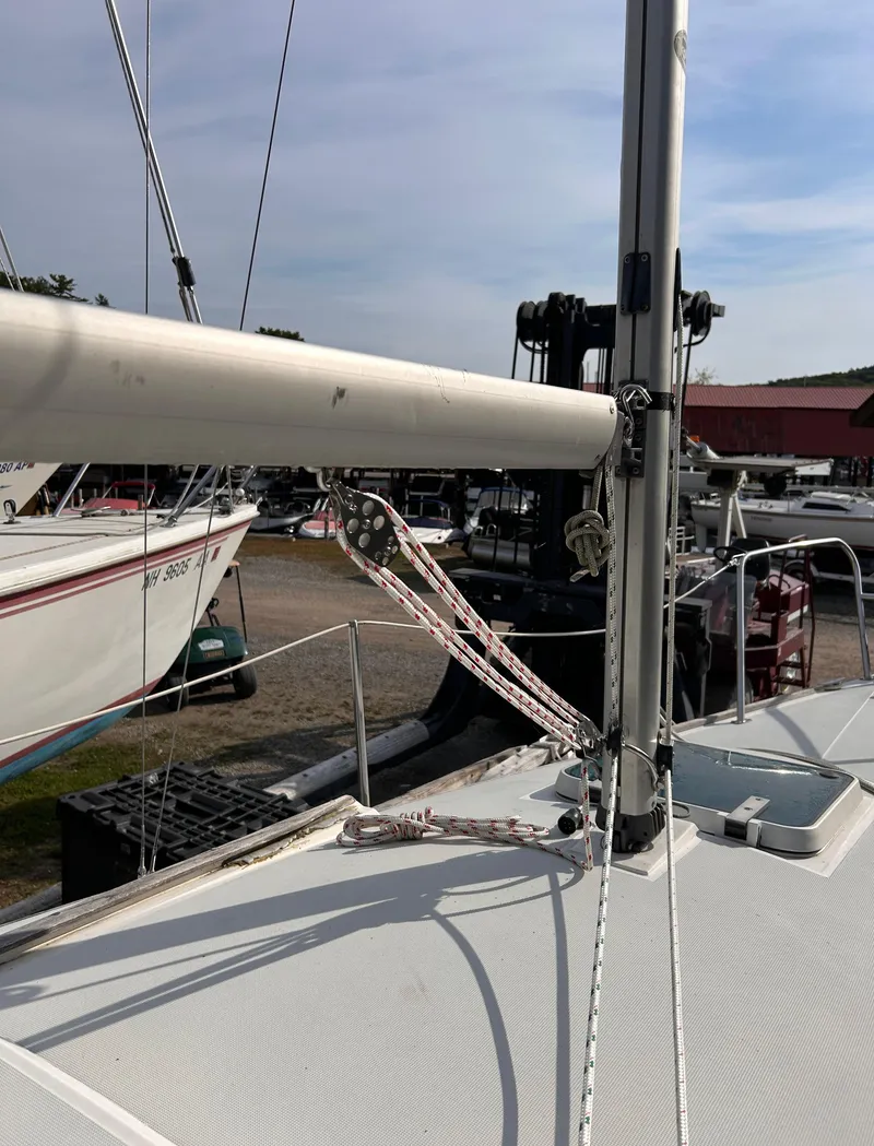 Slide: The Image of 1986 CAL 22 sailboat deck with rigging and mast in marina setting. - 12