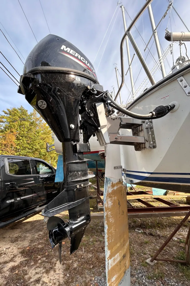 Slide: The Image of 1986 CAL 22 sailboat with Mercury outboard motor, docked outdoors. - 17