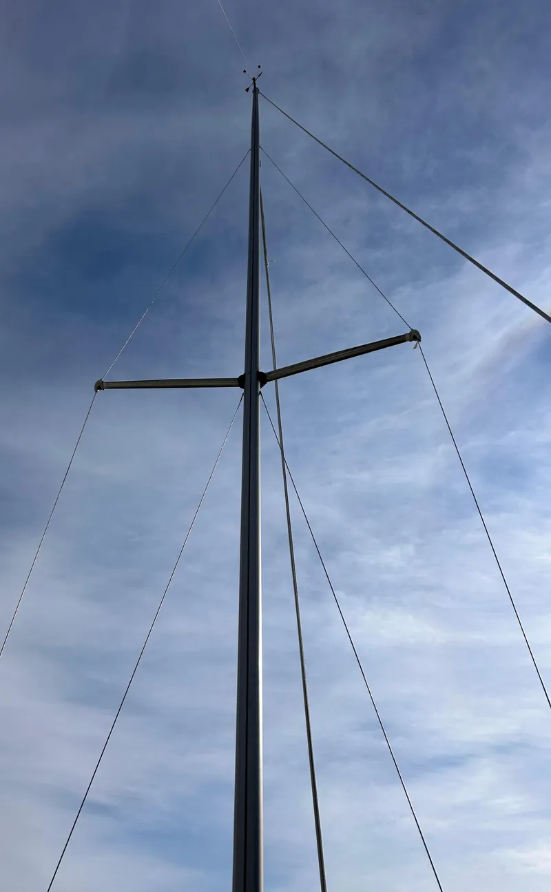 Slide: The Image of Tall sailboat mast against a cloudy sky, CAL 22 model, 1986. - 21
