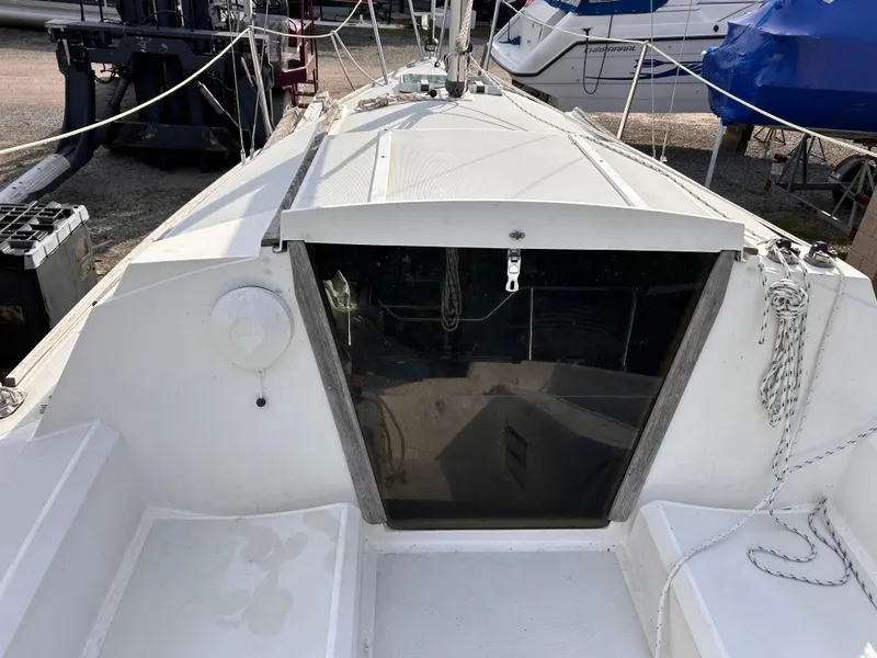 Slide: The Image of 1986 CAL 22 sailboat cockpit with white deck and ropes. - 24