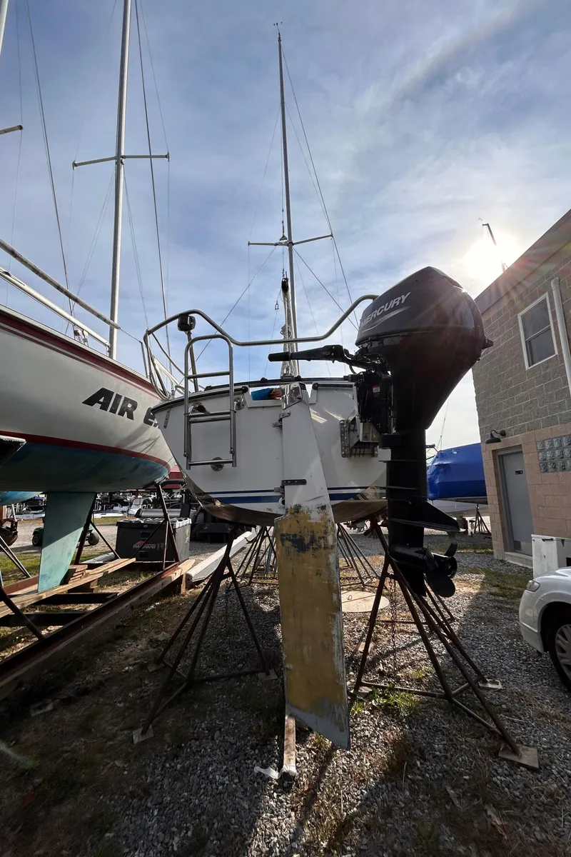 Slide: The Image of 1986 CAL 22 sailboat on stands, outdoor storage, sunny day. - 3