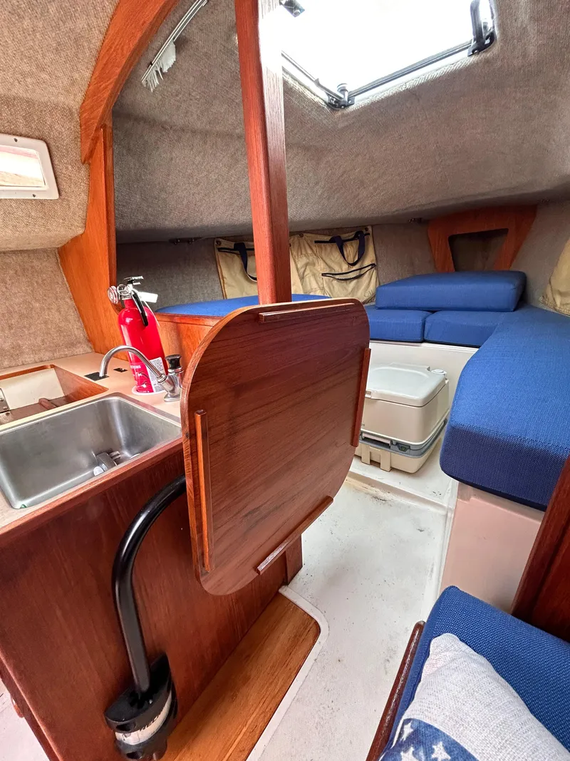 Slide: The Image of Interior of 1986 CAL 22 sailboat with kitchenette, seating, and storage. - 30