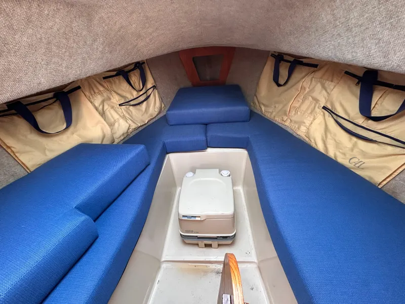 Slide: The Image of Interior of 1986 CAL 22 sailboat with blue cushions and storage bags. - 31