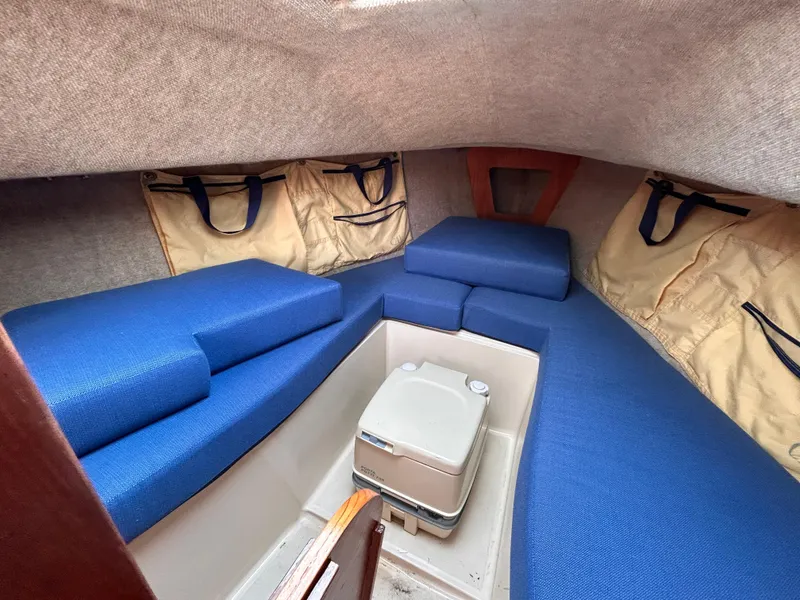 Slide: The Image of Cozy cabin interior of 1986 CAL 22 sailboat with blue cushions and storage bags. - 32