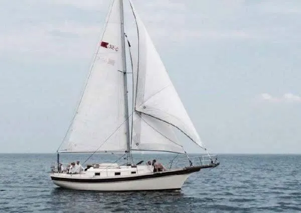 The Image of 1985 Bayfield 32 sailboat cruising on open water under clear skies. - 0