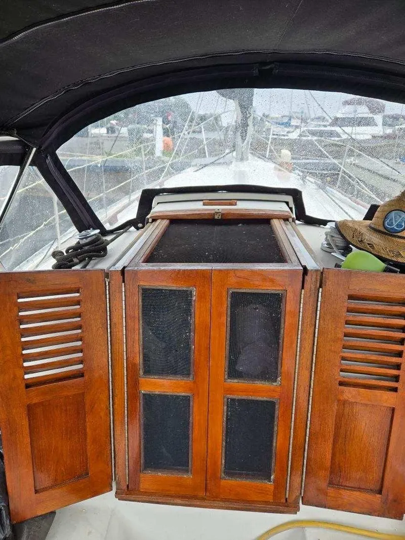 Slide: The Image of 1985 Bayfield 32 sailboat cockpit with wooden hatch doors and covered deck view. - 16