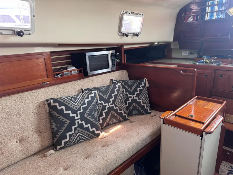 Slide: The Image of Interior of a 1985 Bayfield 32 sailboat with cushions, microwave, and wooden cabinetry. - 19