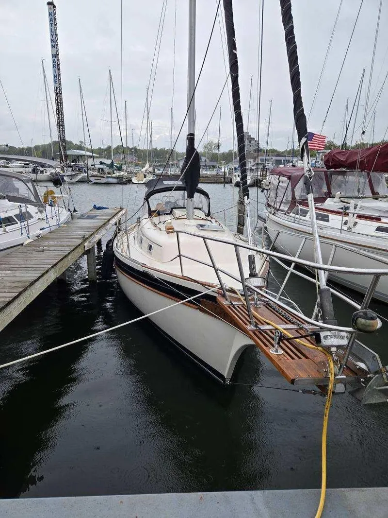 Slide: The Image of 1985 Bayfield 32 sailboat docked in marina, surrounded by other boats. - 2