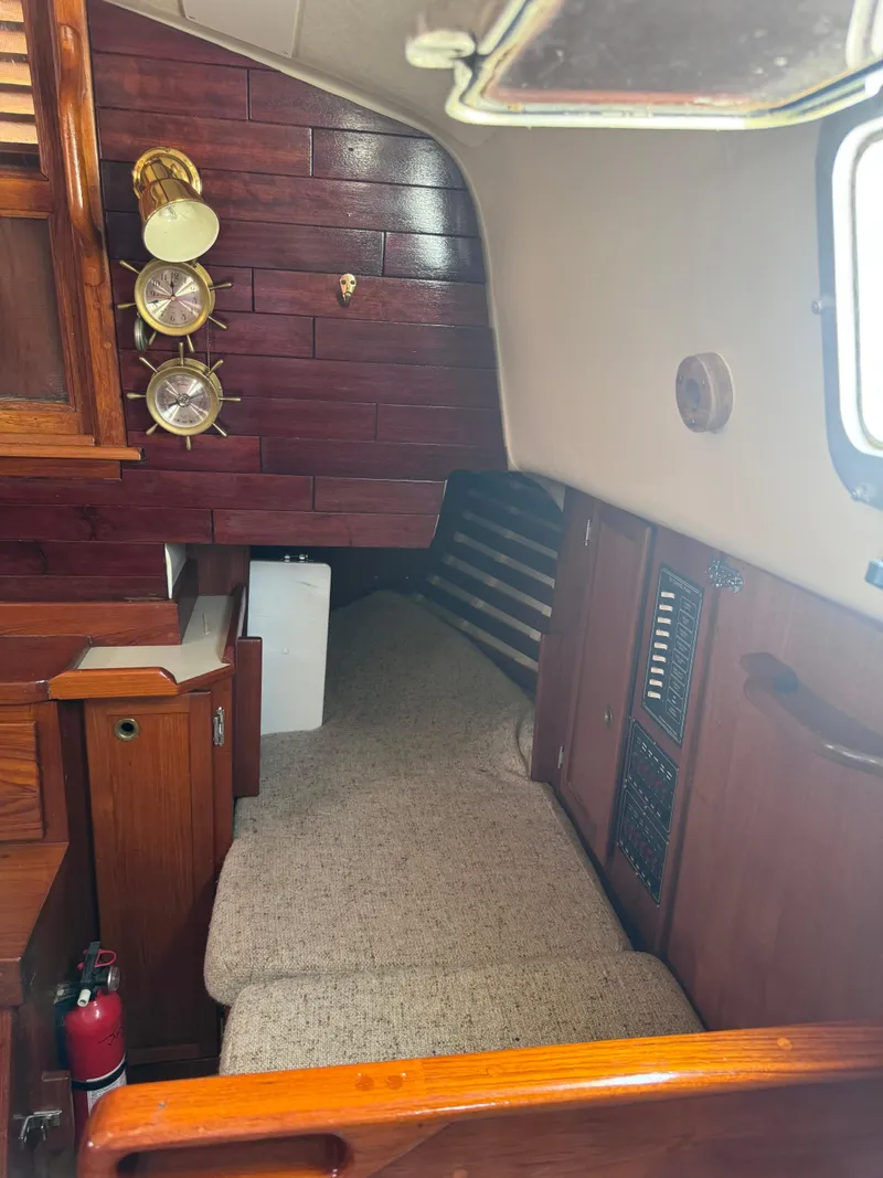 Slide: The Image of Interior of a 1985 Bayfield 32 sailboat with wooden paneling and cozy sleeping area. - 21