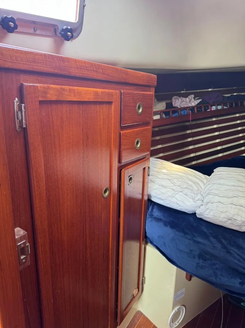 Slide: The Image of 1985 Bayfield 32 sailboat interior with wooden cabinetry and cozy sleeping area. - 26