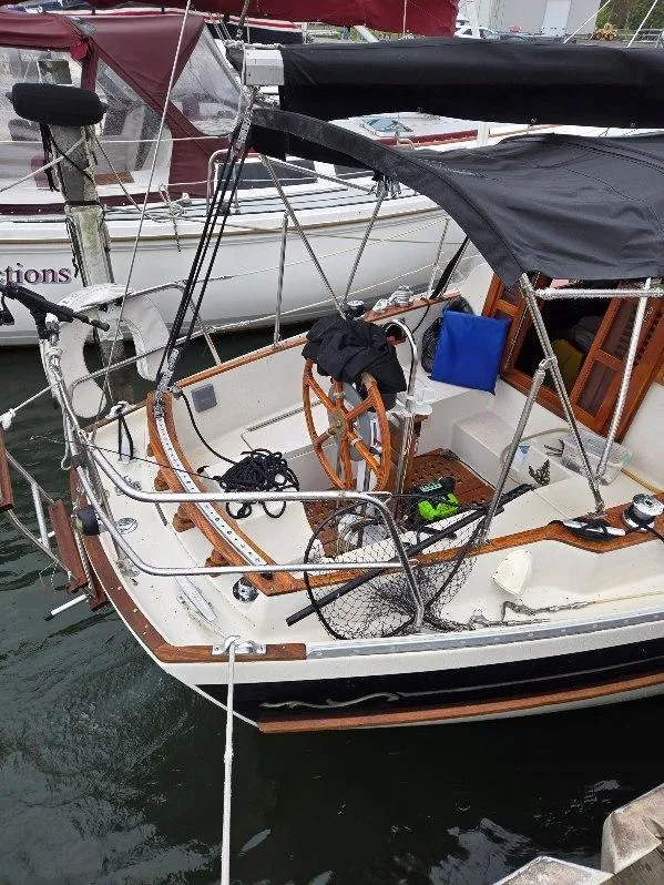 Slide: The Image of 1985 Bayfield 32 sailboat docked, featuring wooden accents and nautical equipment. - 5