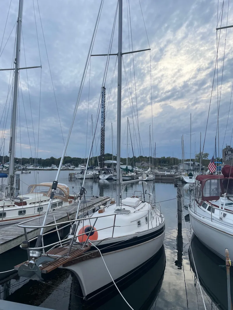 Slide: The Image of 1985 Bayfield 32 sailboat docked in a marina under a cloudy sky. - 6