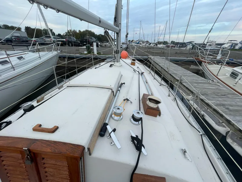 Slide: The Image of 1985 Bayfield 32 sailboat deck with winches and wooden hatch, docked at marina. - 8