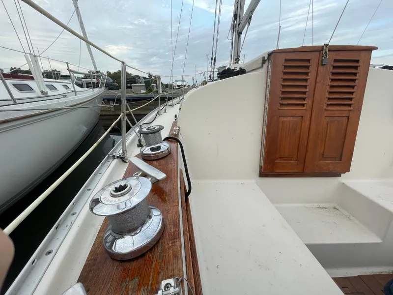 Slide: The Image of 1985 Bayfield 32 sailboat deck with winches and wooden hatch, docked at marina. - 9