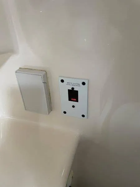 Slide: The Image of Chaparral 260 Signature 2004 waste system control panel on white interior wall. - 24