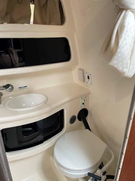 Slide: The Image of 2004 Chaparral 260 Signature boat bathroom with sink and toilet. - 27