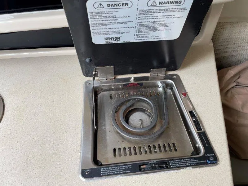 Slide: The Image of Kenyon alcohol stove on 2004 Chaparral 260 Signature boat, open lid, safety warnings visible. - 35