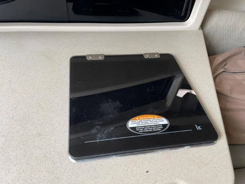 Slide: The Image of Black stove cover on Chaparral 260 Signature 2004 boat countertop. - 36